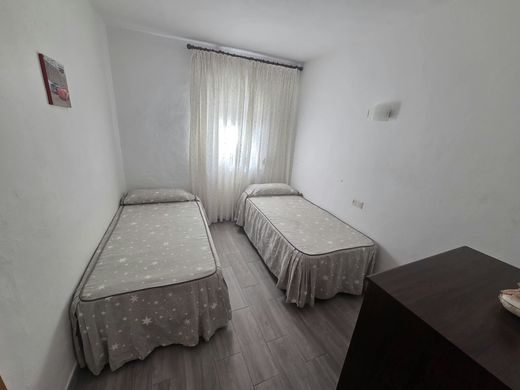 Dormitorio con dos camas individuales, colchas grises con estrellas y una cortina clara