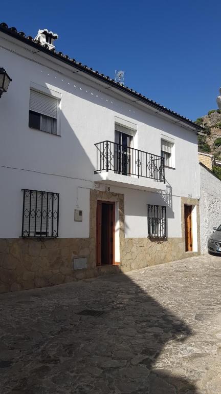 Fachada con balcón sobre la calle empedrada