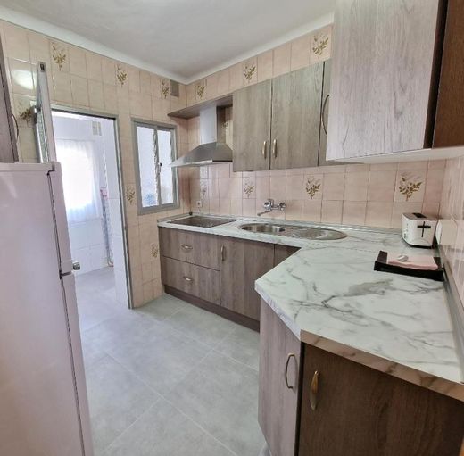 Cocina nueva con muebles de madera clara y encimera veteada