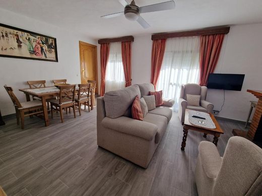 Salón con mesa de comedor, sofá, sillón y televisión