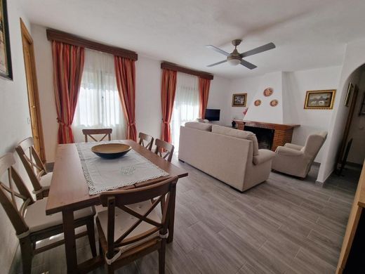 Mesa de comedor en primer plano y, al fondo, el sofá y la chimenea
