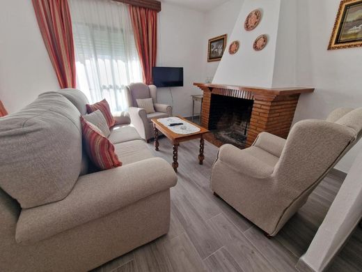 Salón con sofá, sillones y la chimenea de ladrillo