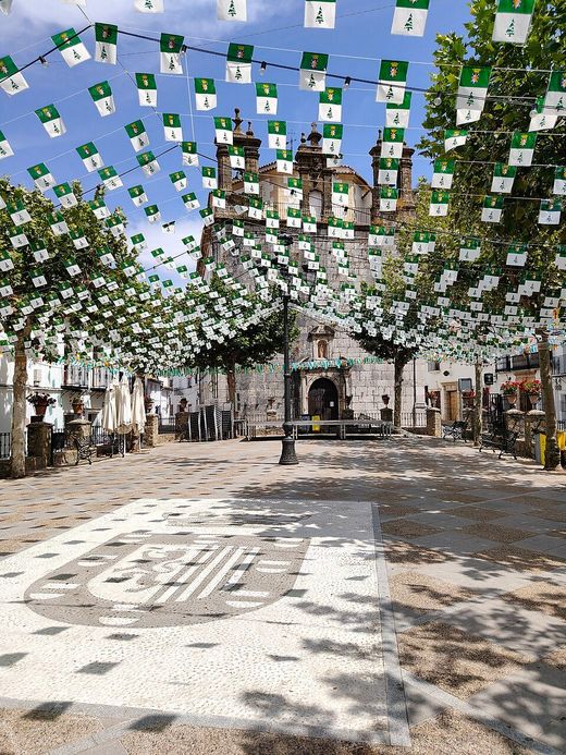 Plaza de España de Grazalema con banderines verdes y blancos y la iglesia al fondo